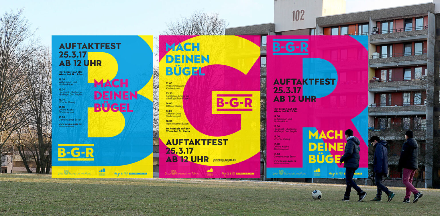 Drei große, bunte Plakate mit der Aufschrift ‚Mach deinen Bügel‘ und Informationen zum Auftaktfest am 25. März 2017 ab 12 Uhr auf der Wiese bei St. Lioba, mit Programmpunkten wie Kinderaktion, Facebook-Challenge, offenem Dialog, offener Küche und gemeinsamem Essen. Die Plakate sind in kräftigen Farben Blau, Gelb und Pink gestaltet. Im Vordergrund laufen drei Jugendliche mit einem Fußball, im Hintergrund sind Wohnhäuser zu sehen.