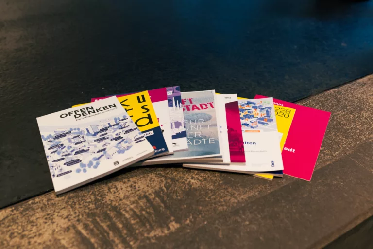 Mehrere bunte Broschüren von urbanista zum Thema Innenstadt liegen nebeneinander.